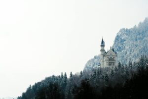 A stunning view of Neuschwanstein Castle surrounded by snow-capped trees and mountains.